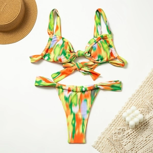 Flat lay of floral bikini set with abstract tie-dye print and bow tie detailing