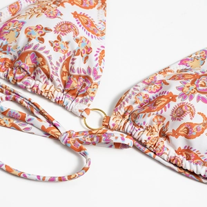 Detail of paisley print bikini top with golden ring connector and adjustable ties