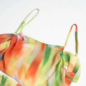 Détail des bretelles réglables et du décolleté plissé sur une robe de plage colorée