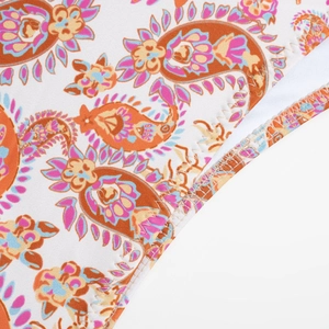 Macro detail of paisley print bikini fabric with colorful ethnic patterns and stitching
