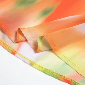 Détail de l'ourlet en mousseline légère avec dégradé orange et vert et couture