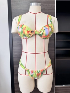Detailed macro view of tie-dye printed bikini with knotted bandeau top and side ruffles