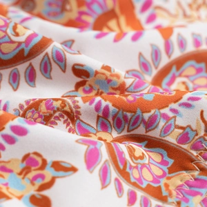 Close-up of bohemian paisley printed fabric with orange, pink and blue colors