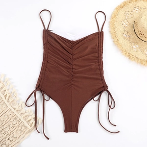 Détail du maillot de bain marron avec fronces, cordon de serrage et accessoires de plage
