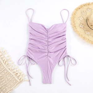 Détail d'un maillot de bain une pièce lilas avec plis et cordons de serrage sur le côté