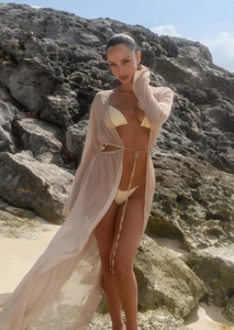 Vue détaillée d'une robe de plage en mousseline beige avec ceinture et texture légère