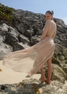 Détail d'une robe de plage longue en mousseline abricot avec découpes et manches longues