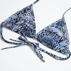 Detail of blue animal print bikini top with adjustable halter ties and smooth fabric