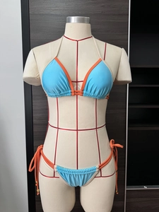 Detail of blue and orange bikini with halter neck ties and gold metal accents