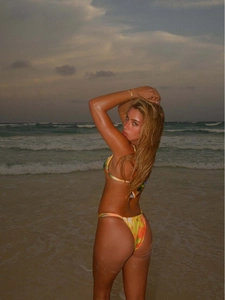 Vibrant tie-dye halter bikini set with high-cut bottoms for women on a beach background