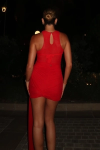 Detail of red ruched mesh dress with lace back cutout and long draped ribbon