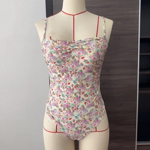 Detail of floral one-piece swimsuit featuring slim straps and pleated chest design