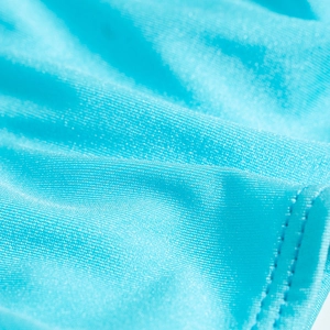 Close-up detail of smooth lake blue nylon bikini fabric with refined woven texture and stitching