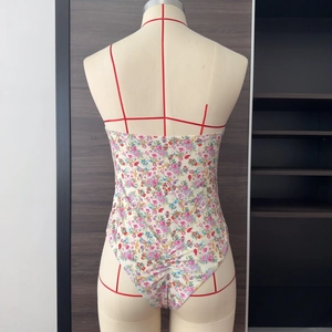 Close-up of floral print one-piece swimsuit with slim straps and low back design