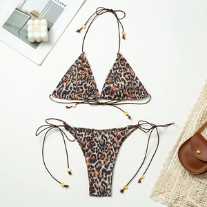 Flat lay of leopard print bikini set with neck ties and decorative gold beads