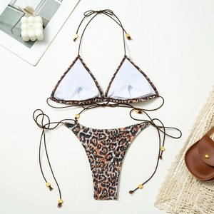 Flat lay of leopard print bikini set with neck ties and gold bead details