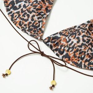 Detail of leopard print bikini with drawstring ties and gold crown engraved metal beads