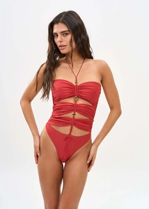 Detail of dark red cutout one-piece swimsuit with golden rings and halter neck design