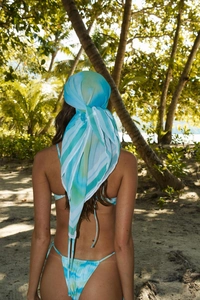 Détail du bas de bikini dégradé tie-dye et du foulard en mousseline assorti à la plage