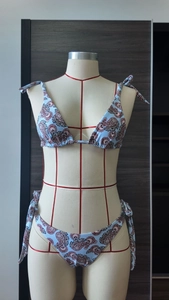 Dettaglio bikini blu con stampa paisley che mostra i lacci laterali e le trame
