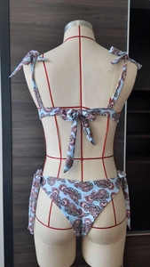 Vista posteriore del bikini con stampa paisley e lacci regolabili su un manichino da esposizione