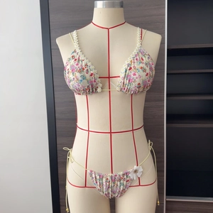 Détail du bikini floral avec bretelles en dentelle marguerite et fleur 3D sur le côté