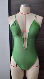 Détail d'un maillot de bain vert olive avec décolleté en V profond et boucle métallique