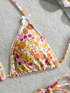 Haut de bikini floral avec bordure en dentelle blanche et petit nœud sur tissu beige