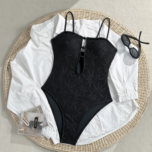 Détail d'un maillot de bain noir en dentelle avec motifs de feuilles et découpe