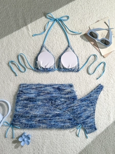 Three-piece light blue mohair bikini set with drawstring skirt on white carpet