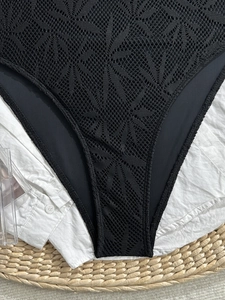 Détail de maillot de bain en dentelle noire avec texture jacquard géométrique complexe