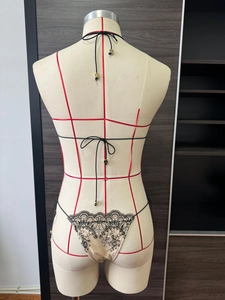 Détail du bas de bikini champagne avec broderie florale noire et liens sur les côtés