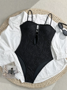 Détail d'un maillot de bain noir avec motifs de palmiers crochetés et boutons