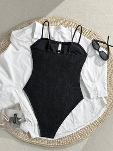 Vue détaillée d'un maillot de bain une pièce en dentelle noire avec lunettes de soleil et sac