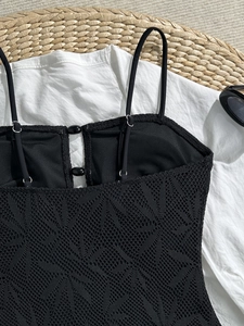 Détail du maillot de bain noir avec dentelle jacquard texturée et boutons perlés