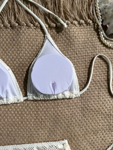 Dettaglio del top bikini all'uncinetto bianco con imbottiture rimovibili e pizzo a onde