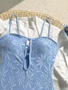 Détail de maillot de bain en dentelle florale bleu clair avec bretelles et boutons fins