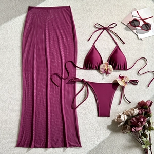 Three-piece burgundy bikini set with mesh long skirt and decorative orchid accents