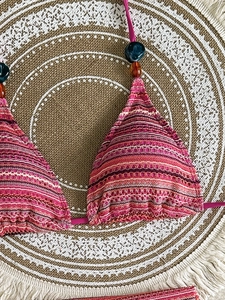 Close-up of crochet halter bikini top with vibrant stripes and decorative beads