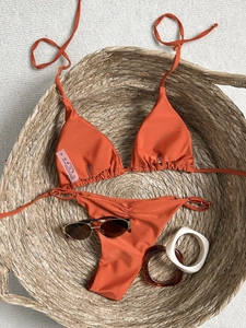 Solid orange two-piece bikini set with starfish charms and side-tie ruffled bottoms
