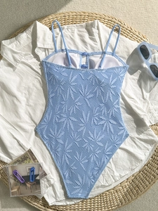 Détail d'un maillot de bain crochet bleu clair avec motifs de feuilles et boutons décoratifs