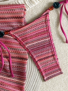 Close-up of pink striped crochet bikini with textured beads and elastic knit details