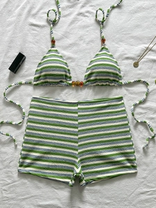 Dettaglio del top bikini a righe con perle d'ambra e tessuto a maglia testurizzato su bianco