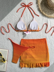 Detailed view of 3-piece gradient bikini set with textured fabric and floral accent
