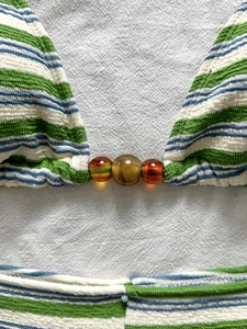 Dettaglio macro di bikini a righe in tessuto testurizzato con perle di resina