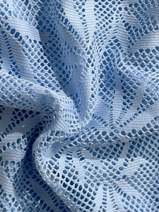 Gros plan sur un maillot de bain bleu clair avec des motifs géométriques en dentelle