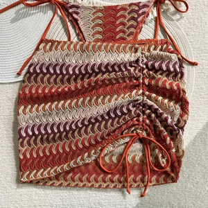 Detail of bohemian crochet knit halter top and side drawstring skirt with wavy texture