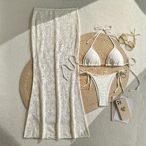 Vue détaillée à plat d'un bikini en crochet crème avec jupe de plage longue transparente