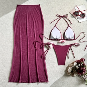 Flat lay of wine red three-piece bikini set with mesh skirt and 3D floral details