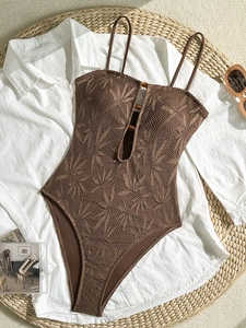 Détail d'un maillot de bain marron avec texture crochet évidée et boutons ambrés